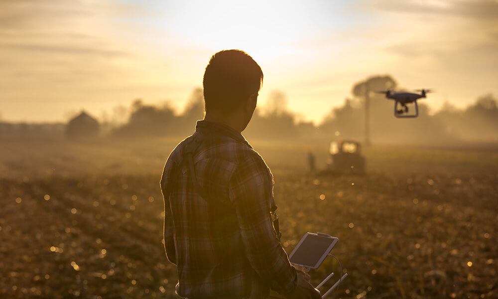 farmer in field flying drones